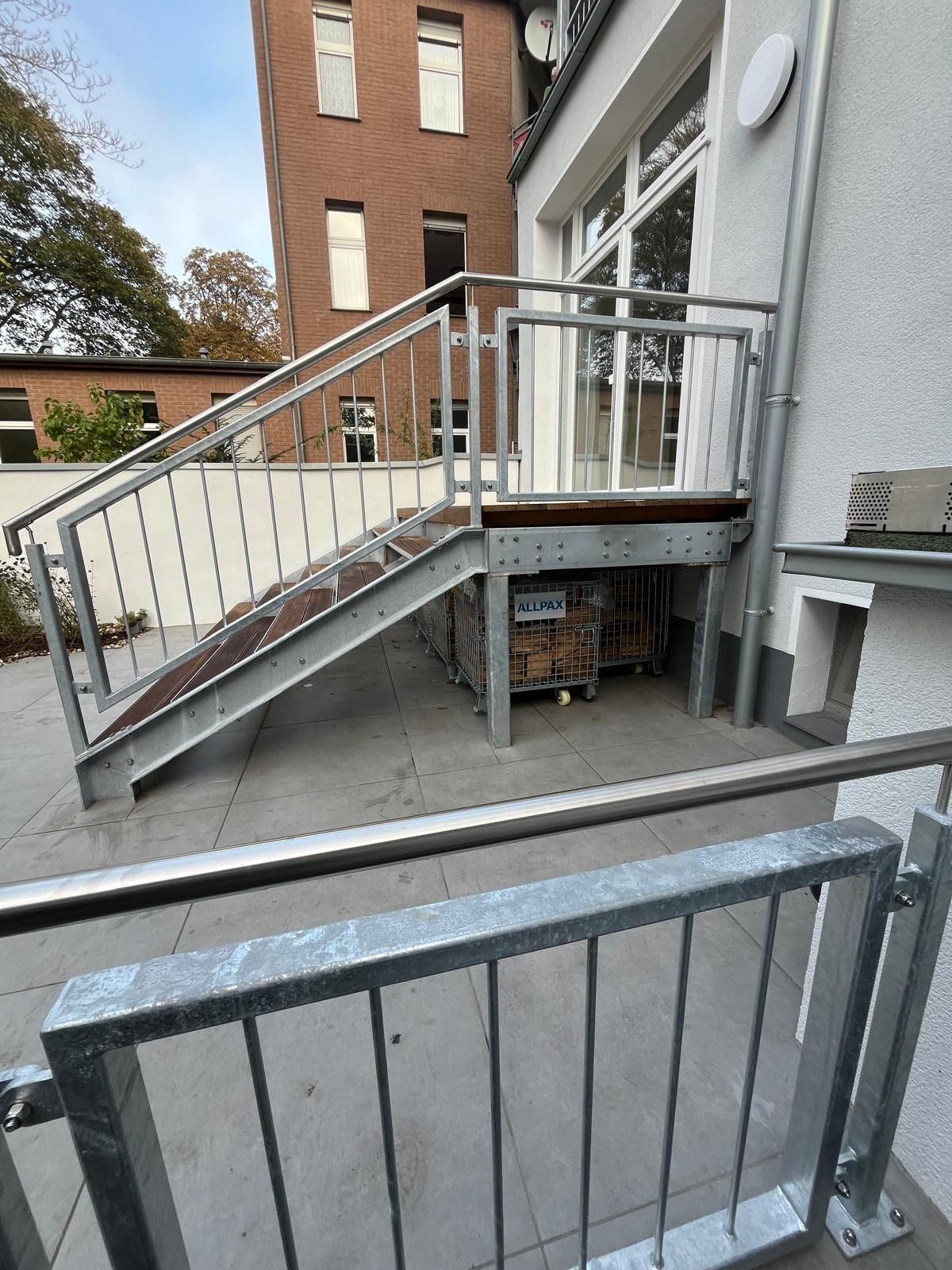 Metalltreppe, die zu einer Tür mit Geländer führt, Grautöne.