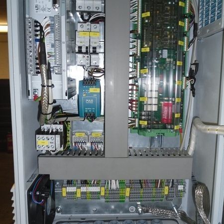 Elektrisches Bedienfeld mit verschiedenen Komponenten, Kabeln und einem Kühlventilator.
