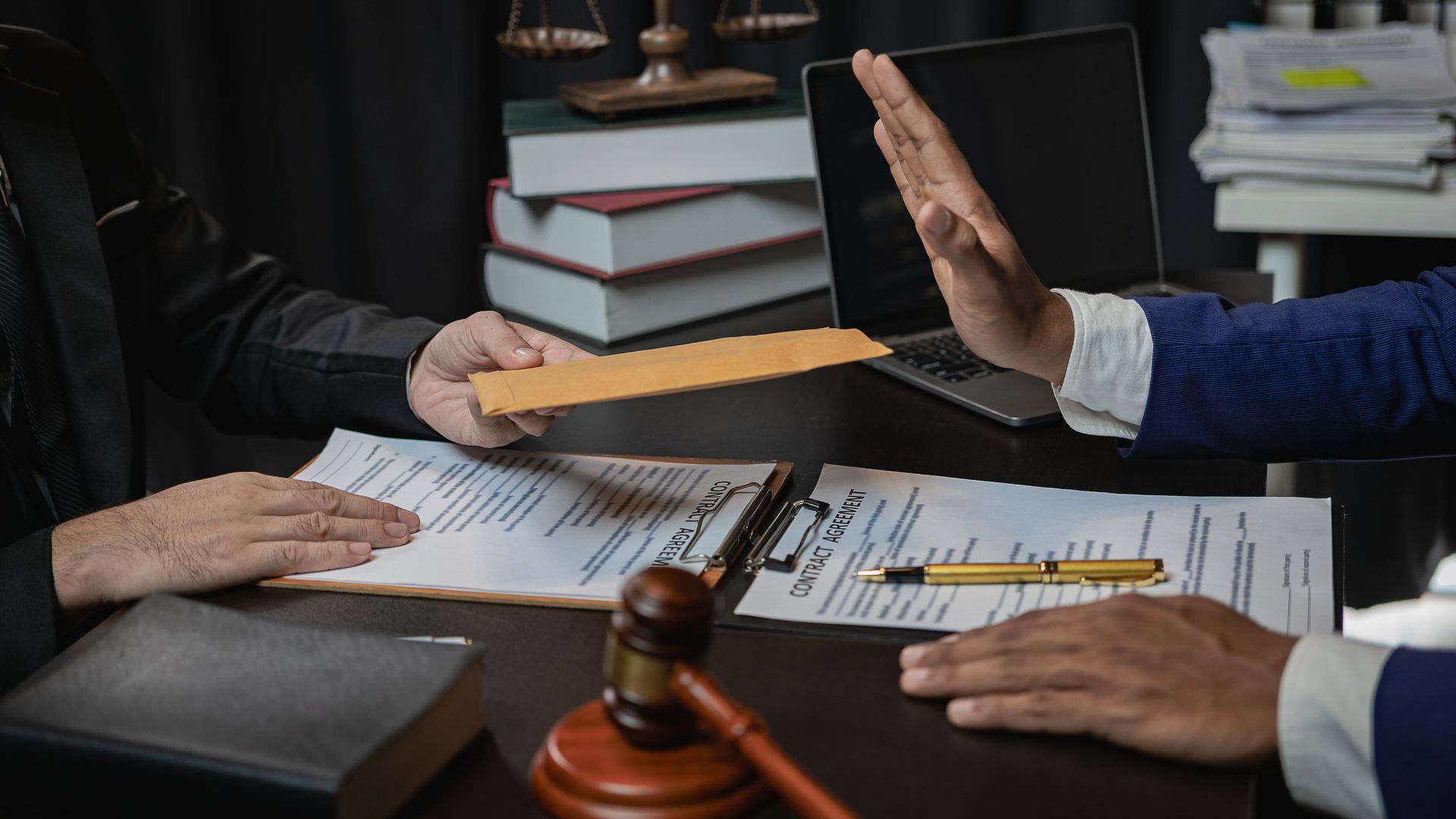 Un homme tendant une enveloppe à un autre qui refuse
