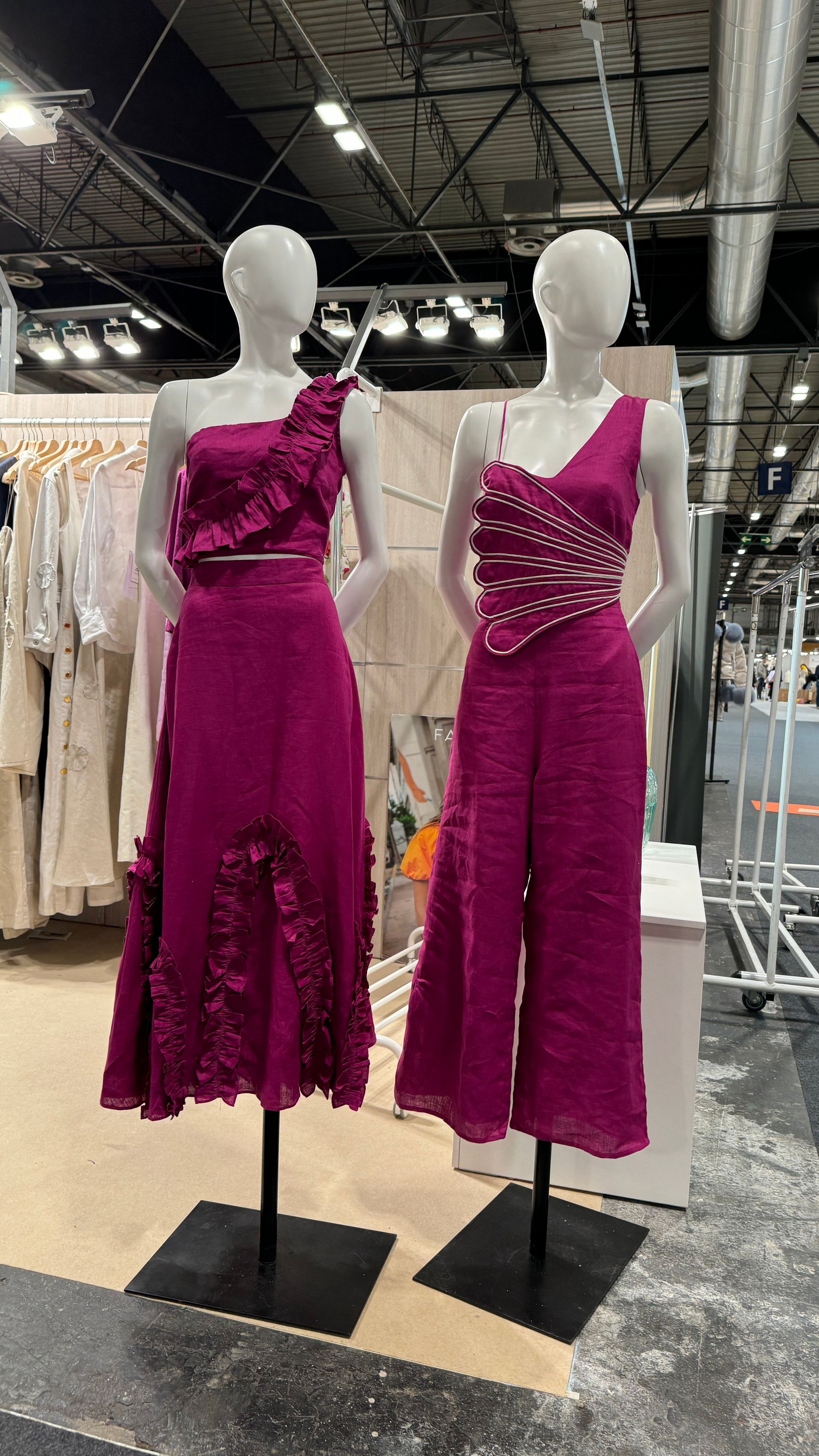 Dos maniquíes con vestidos morados están parados uno al lado del otro en una tienda.