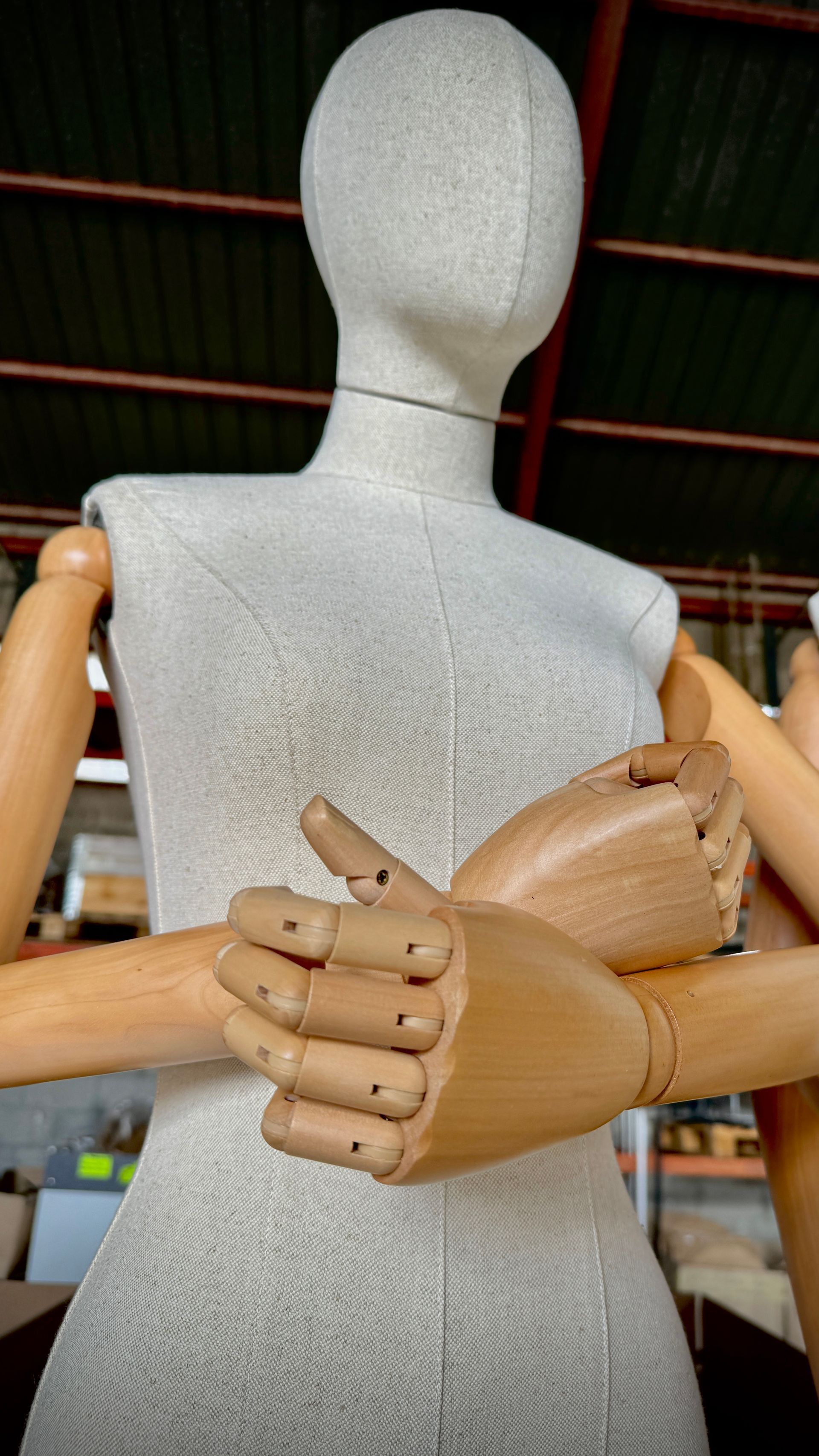 Un maniquí con manos de madera está haciendo un gesto de aprobación con el pulgar hacia arriba.