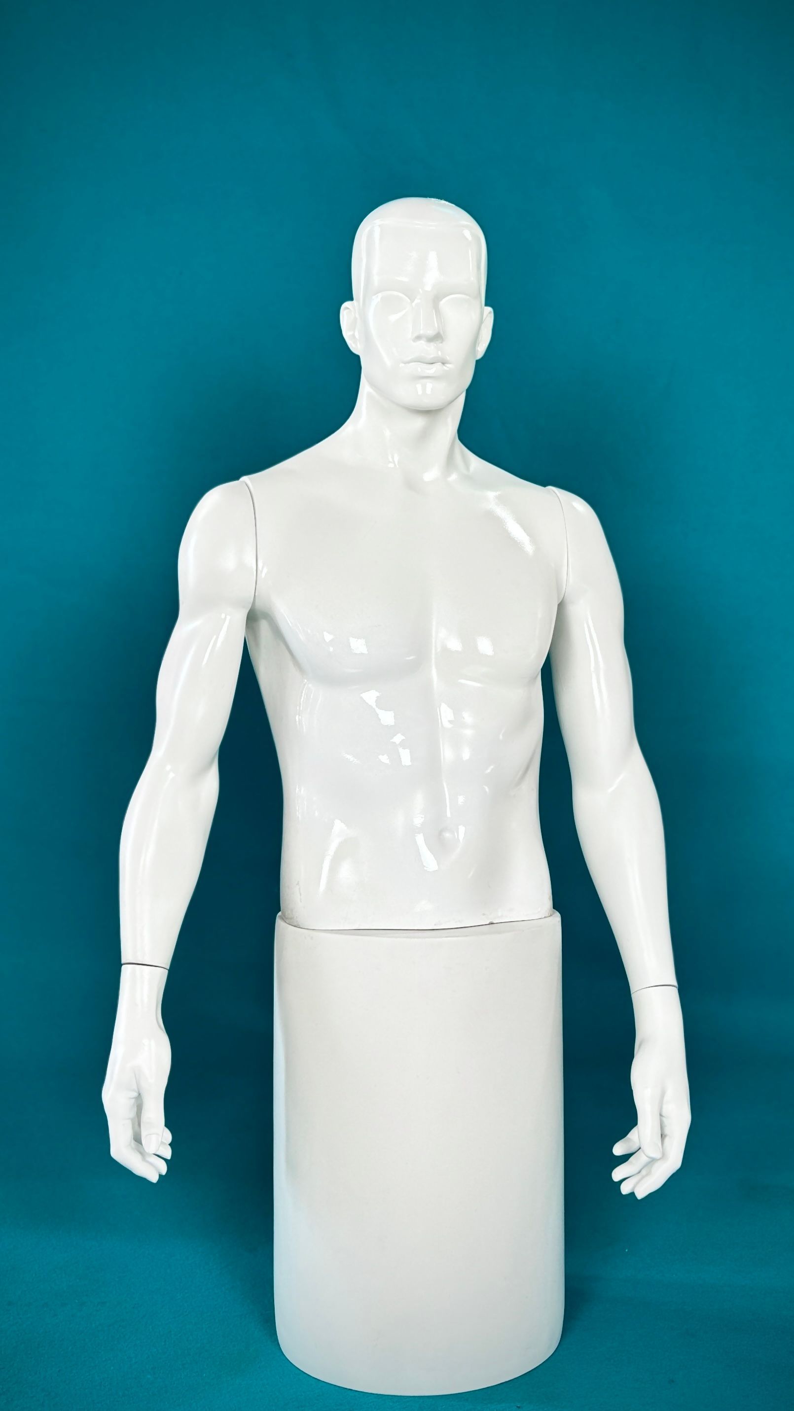 Un maniquí blanco está de pie sobre un fondo azul.