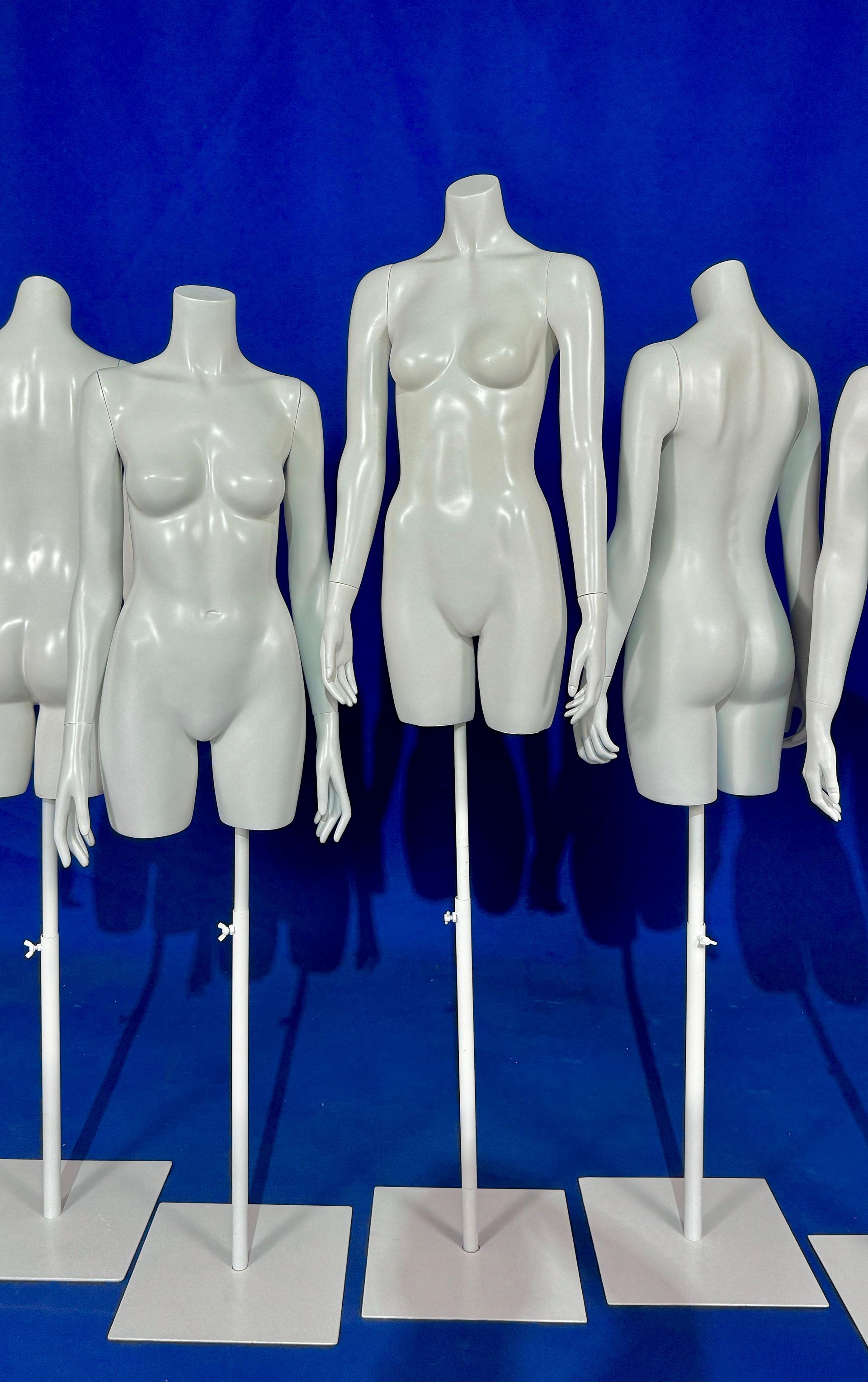 Una fila de maniquíes femeninos blancos están alineados en una fila