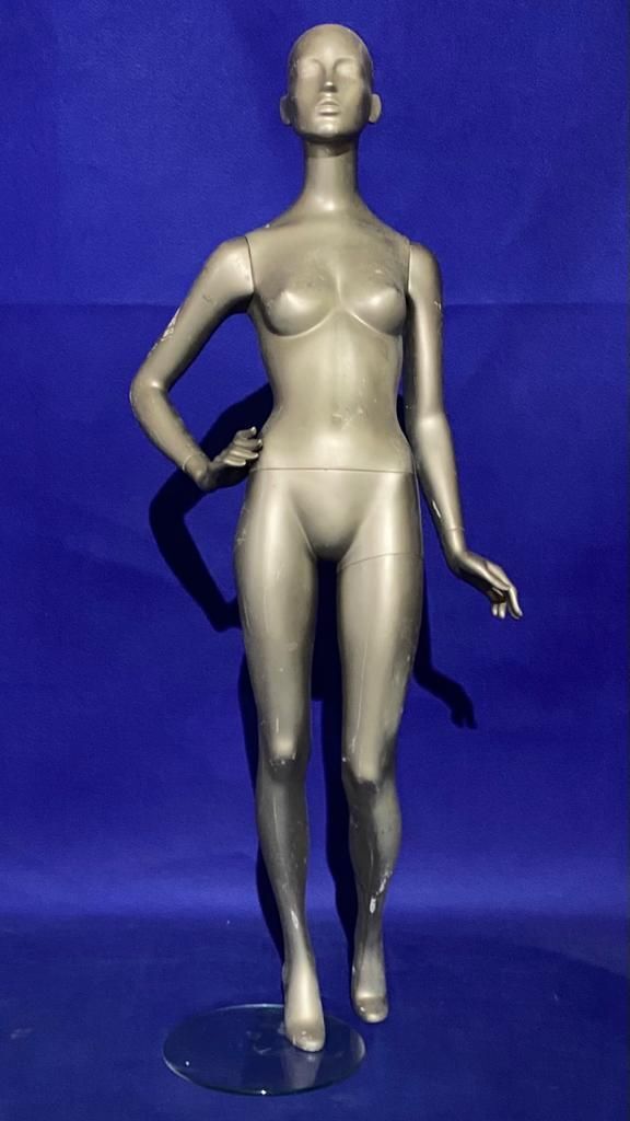 Un maniquí femenino está de pie con las manos en las caderas sobre un fondo azul.