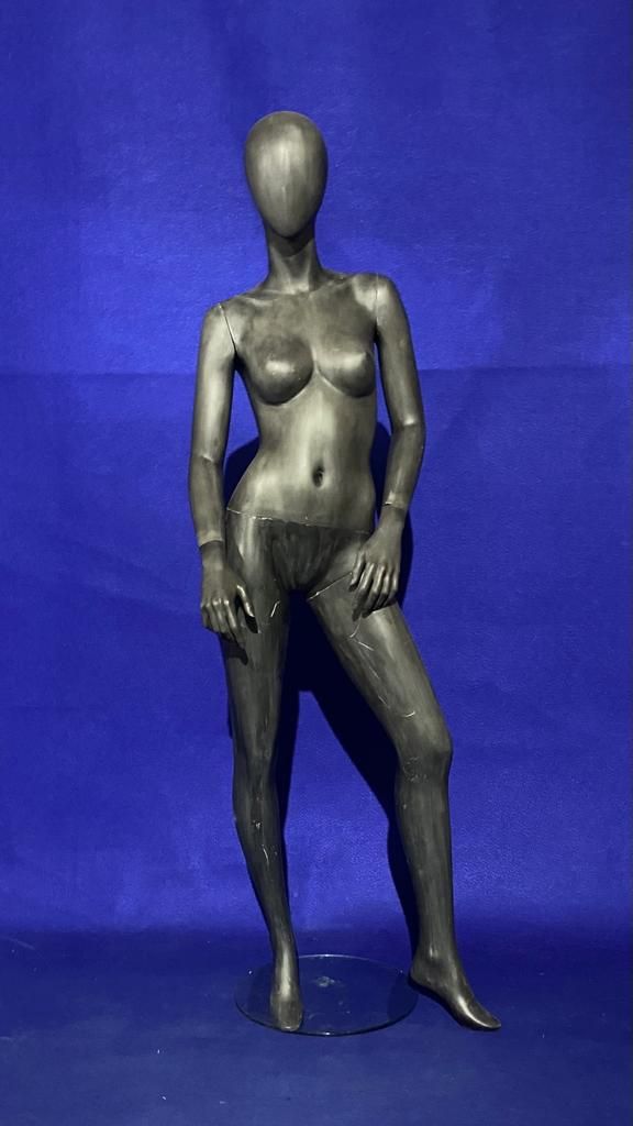 Un maniquí femenino sin cabeza está de pie sobre un fondo azul.