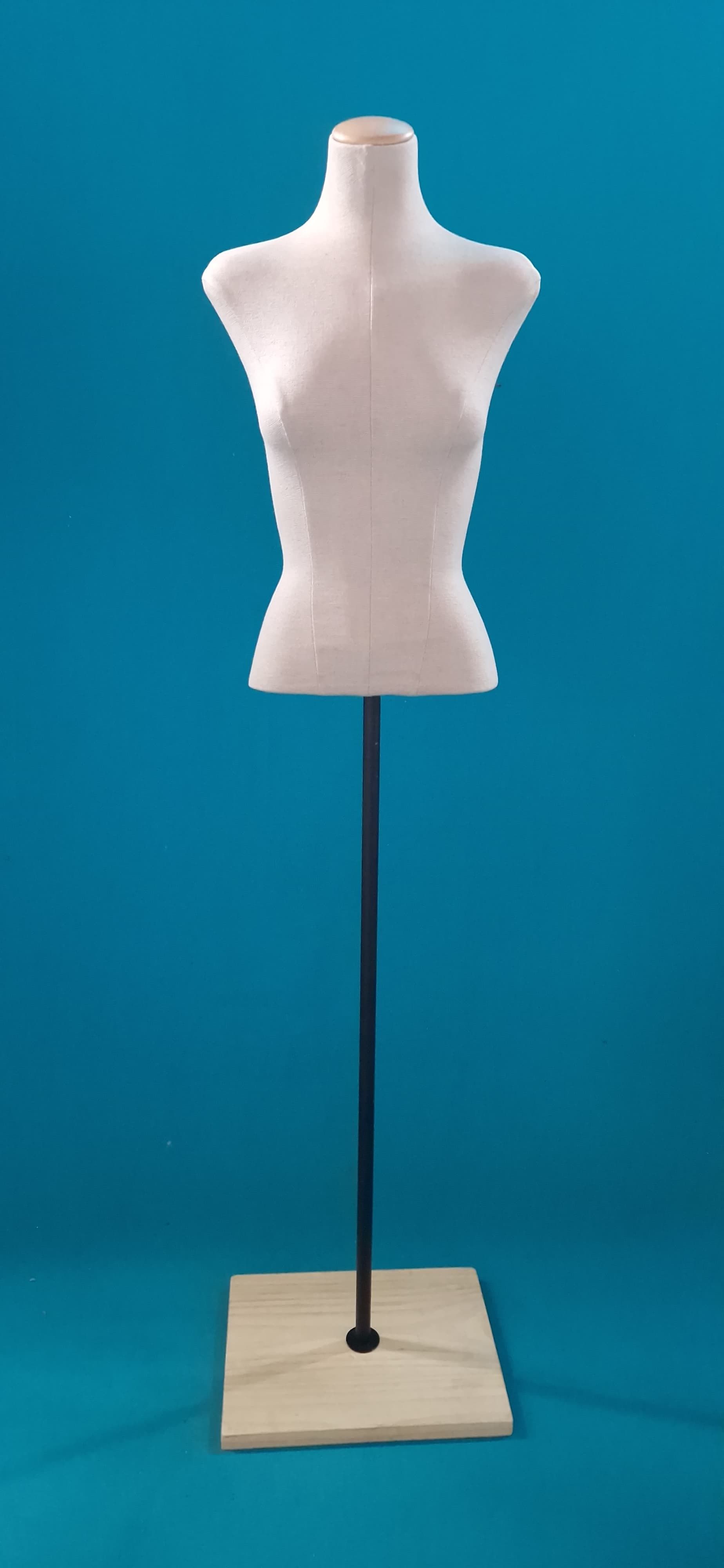 Un maniquí blanco está de pie sobre un fondo azul.