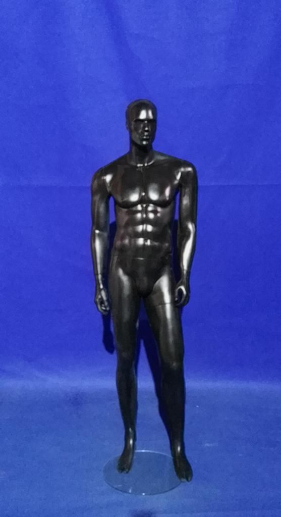 Un maniquí masculino negro está parado frente a un fondo azul.