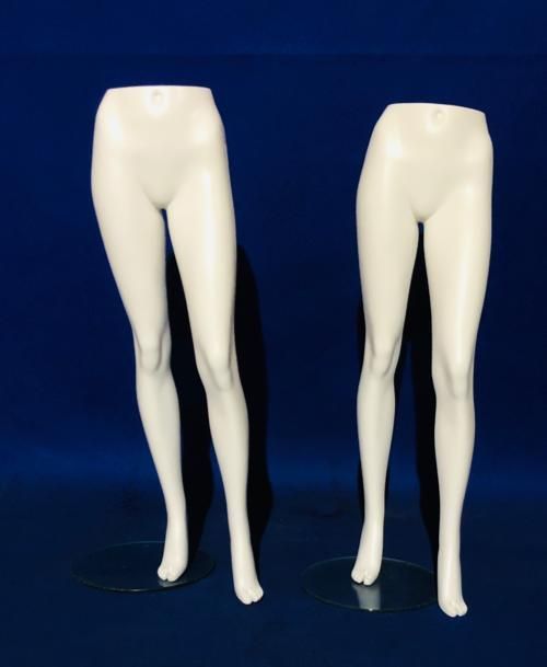 Un par de piernas de maniquí blancas sobre un fondo azul.