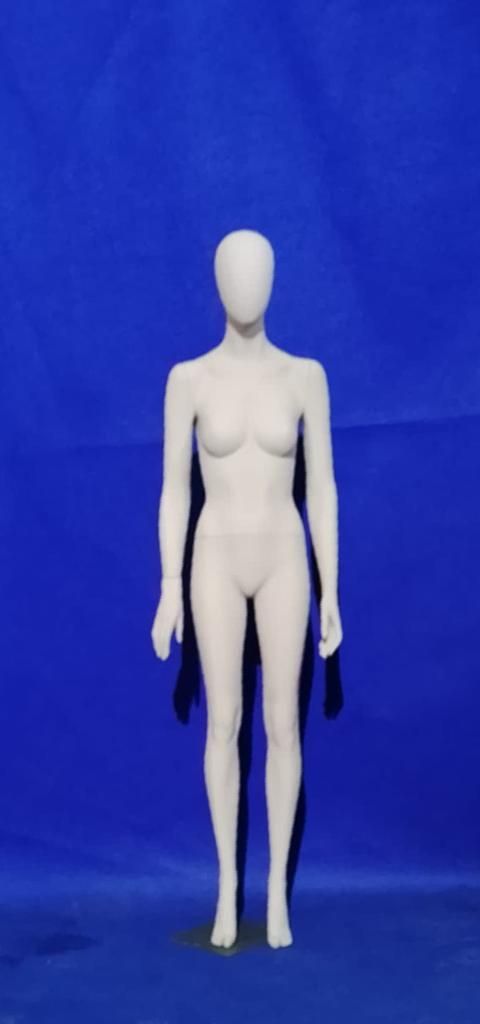 Un maniquí femenino blanco está de pie sobre un fondo azul.