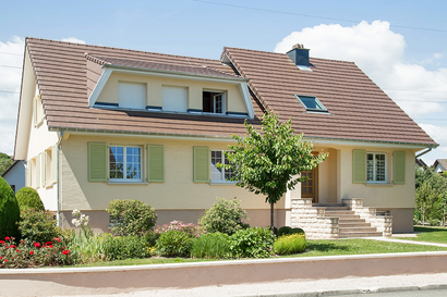 Une grande maison avec un arbre devant