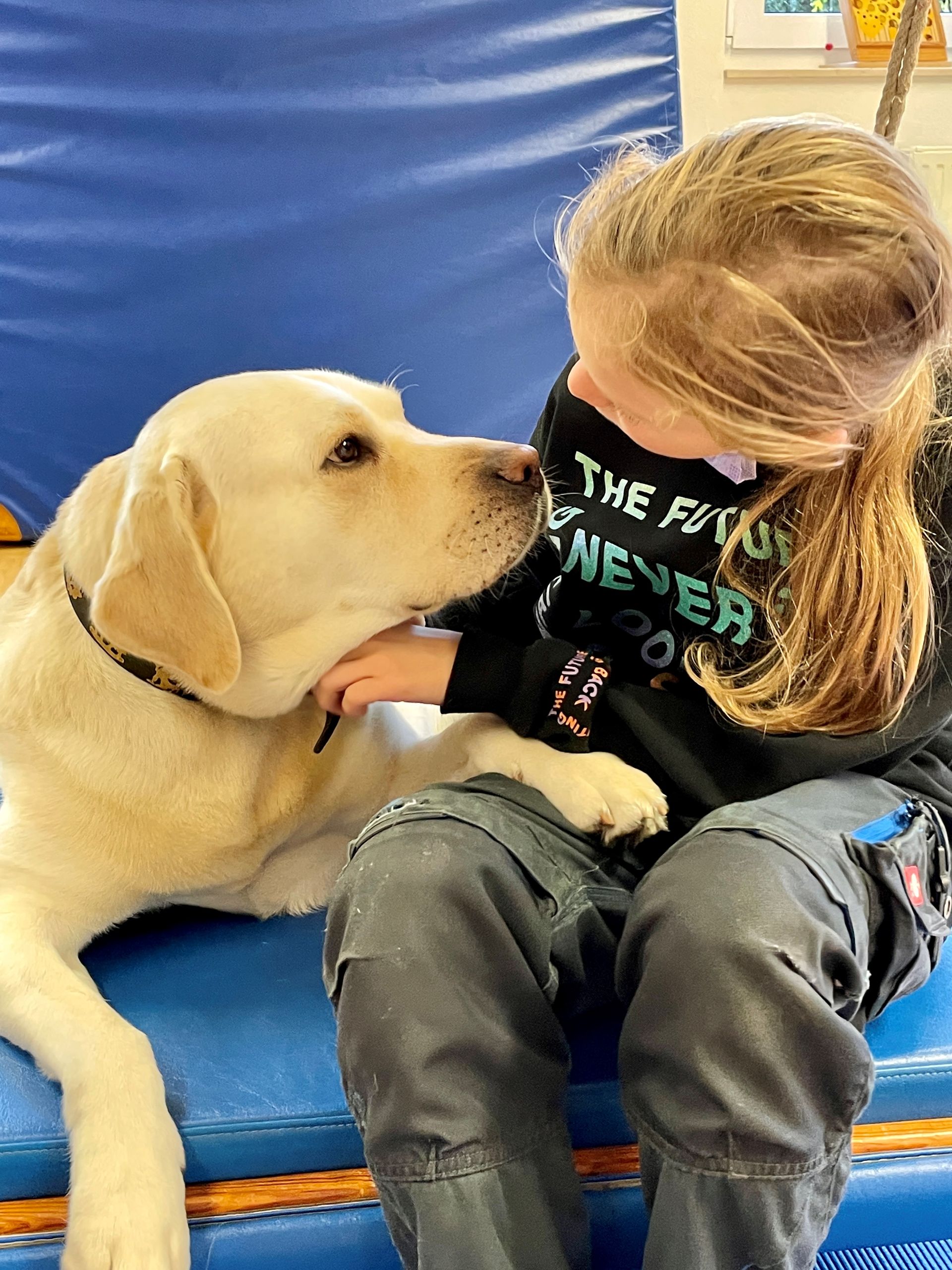 Ein Hund unterstützt ein Kind mit seiner Nähe