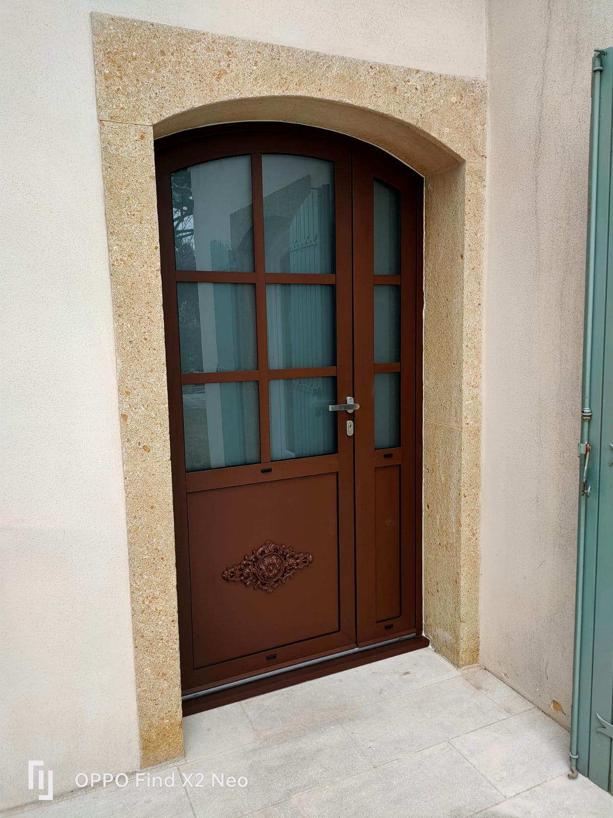Une porte d'entrée marron avec des carreaux.