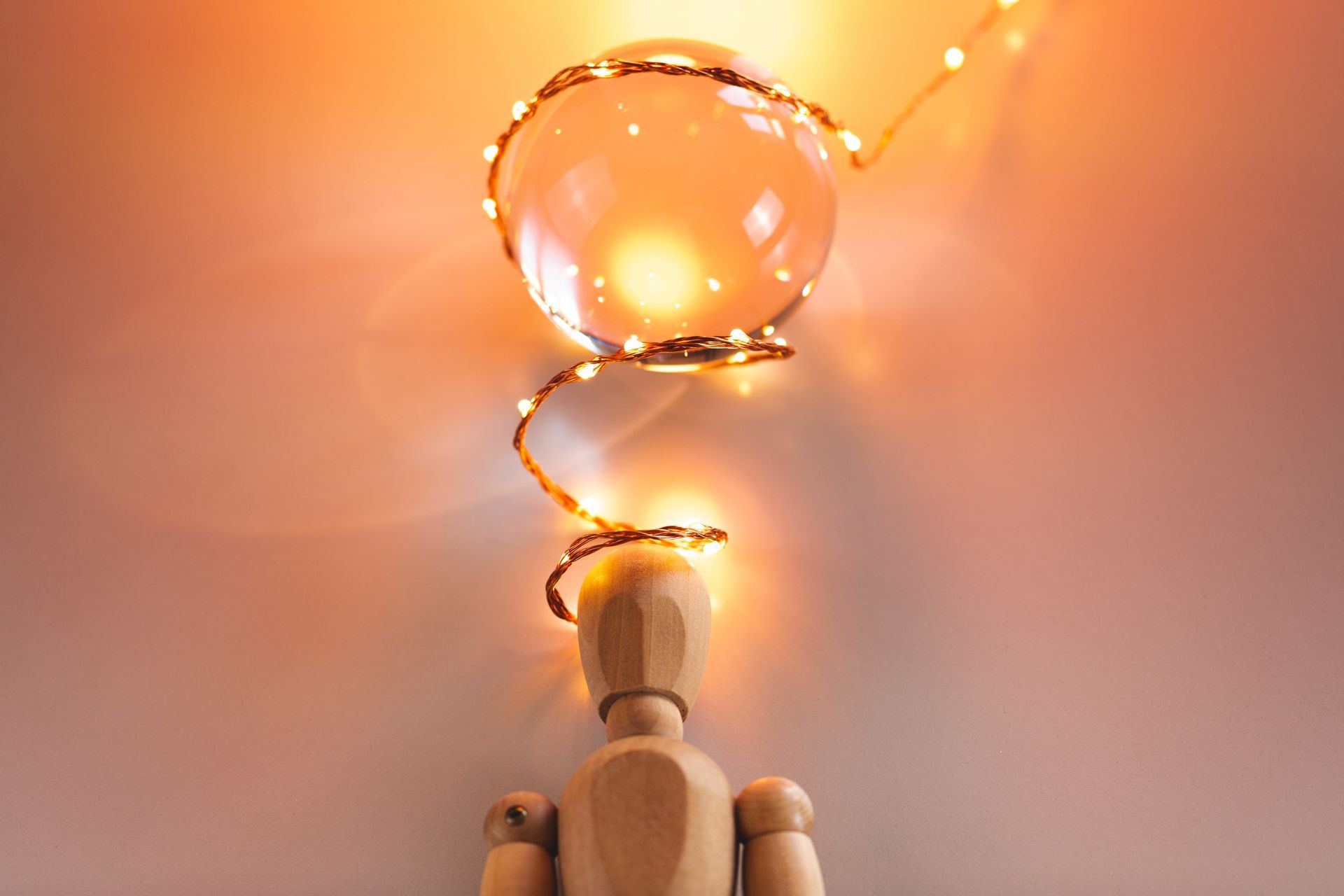 Un pantin en bois sous une boule lumineuse