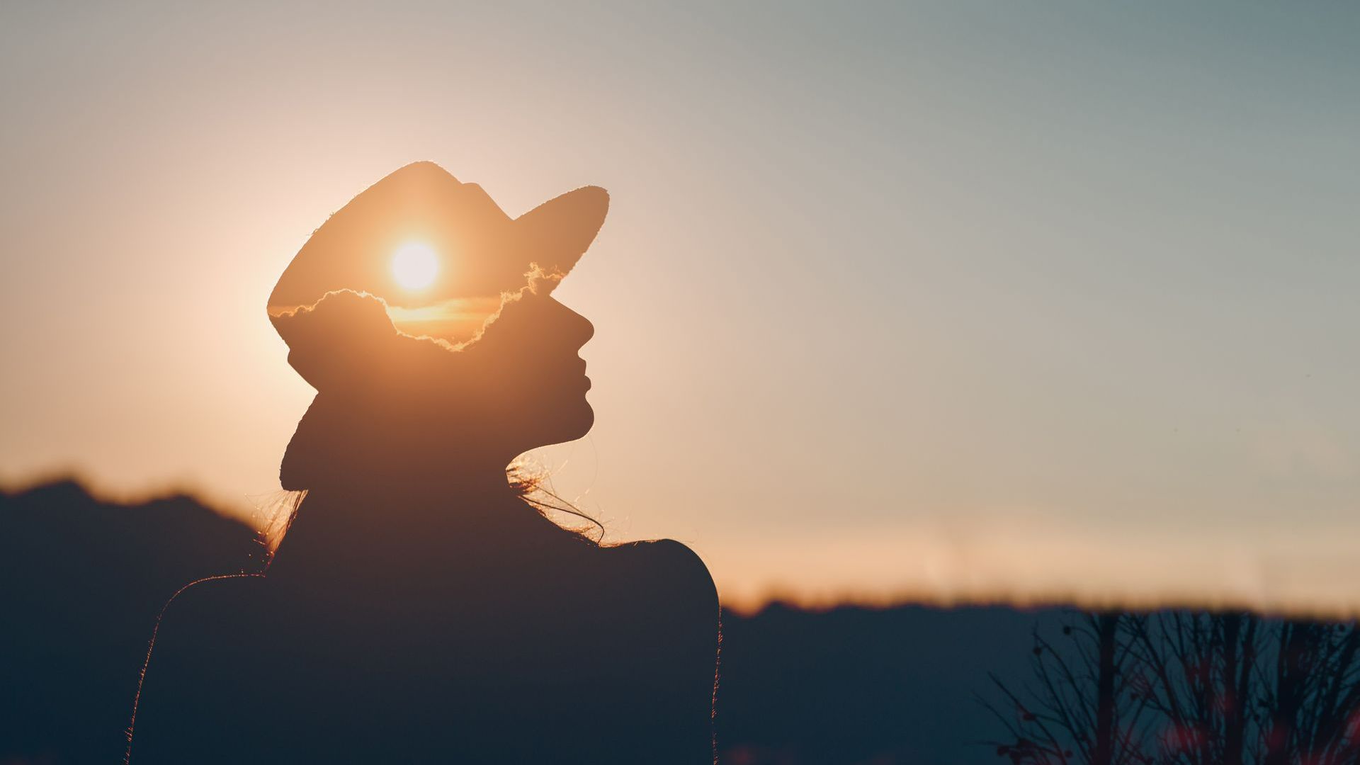Silhouette de femme au coucher de soleil, elle a un soleil dans la tête