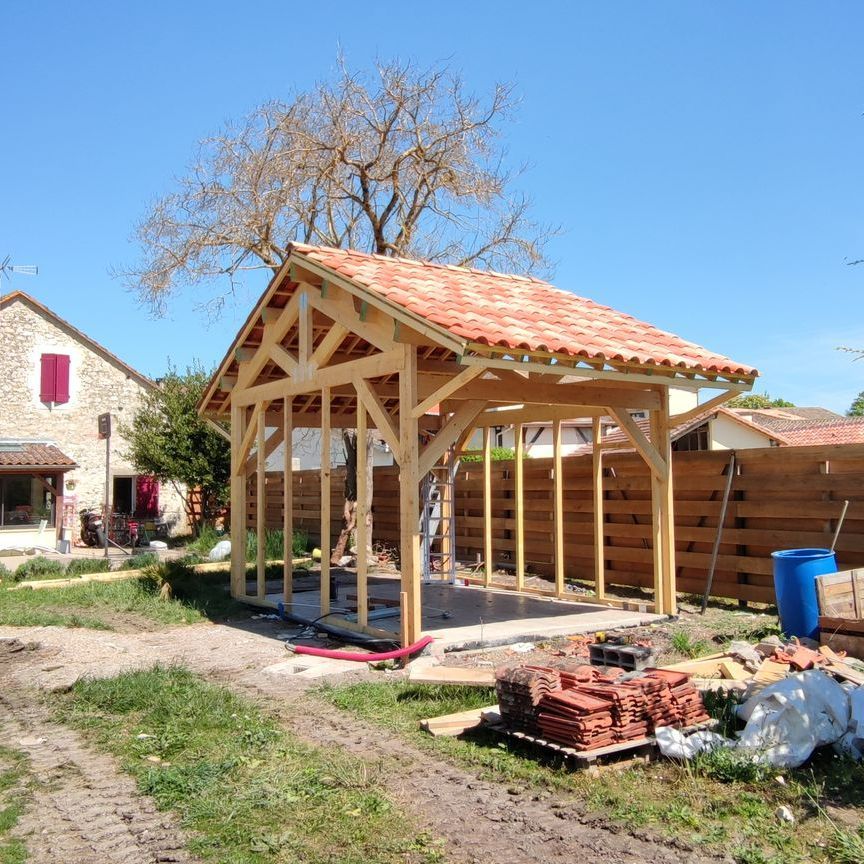 Un homme sur une charpente en bois
