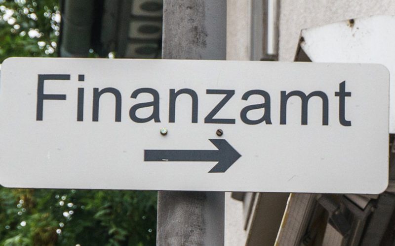 Ein Schild mit der Aufschrift „Finanzamt“ und einem Pfeil nach rechts