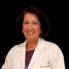 Mujer con bata blanca de laboratorio sonríe.