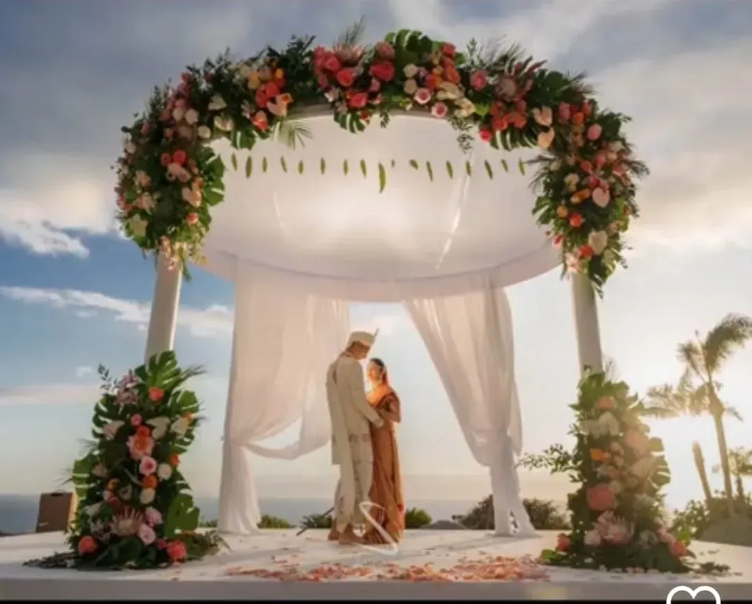 Una novia y un novio se besan bajo un dosel decorado con flores.