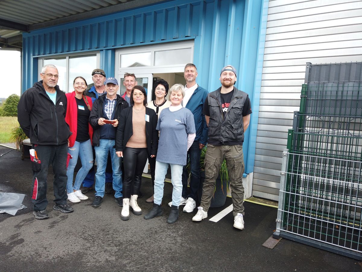 Eine Gruppe von Menschen posiert vor einem Gebäude für ein Foto.