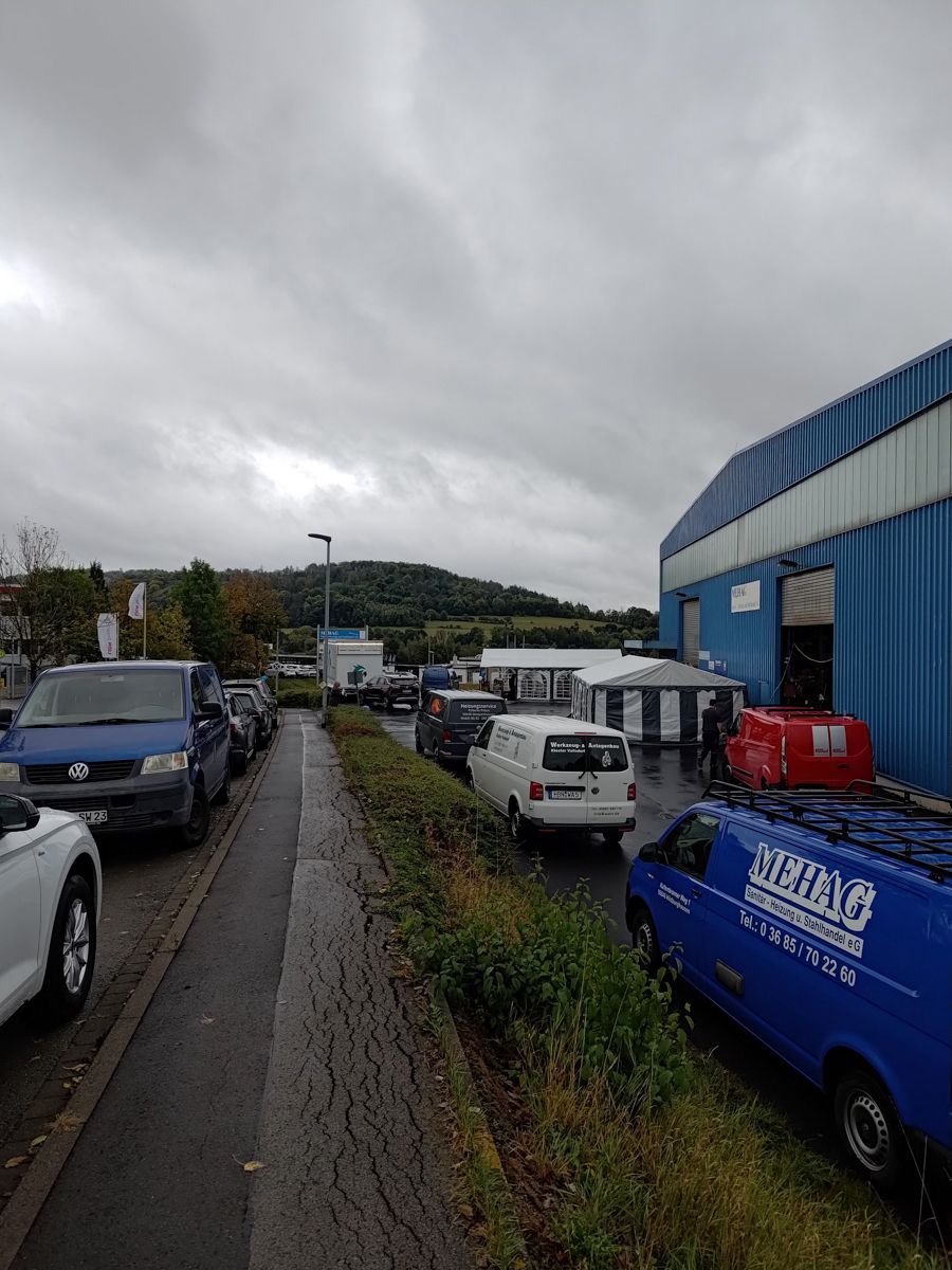 Mehrere Autos parken am Straßenrand vor einem Gebäude.