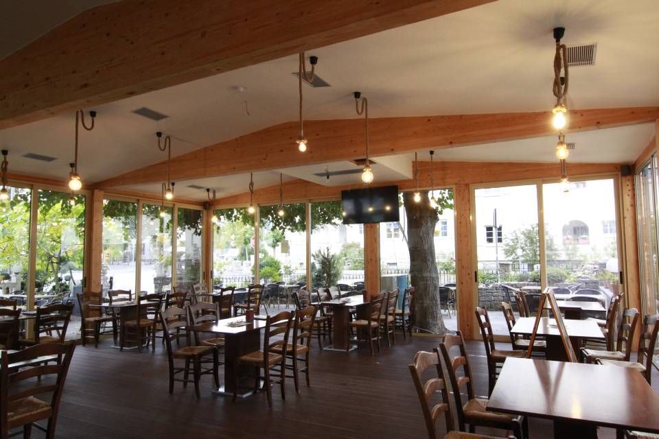 Innenbereich von Restaurant Olympia mit bodenlangen Fenstern mit Gartenblick