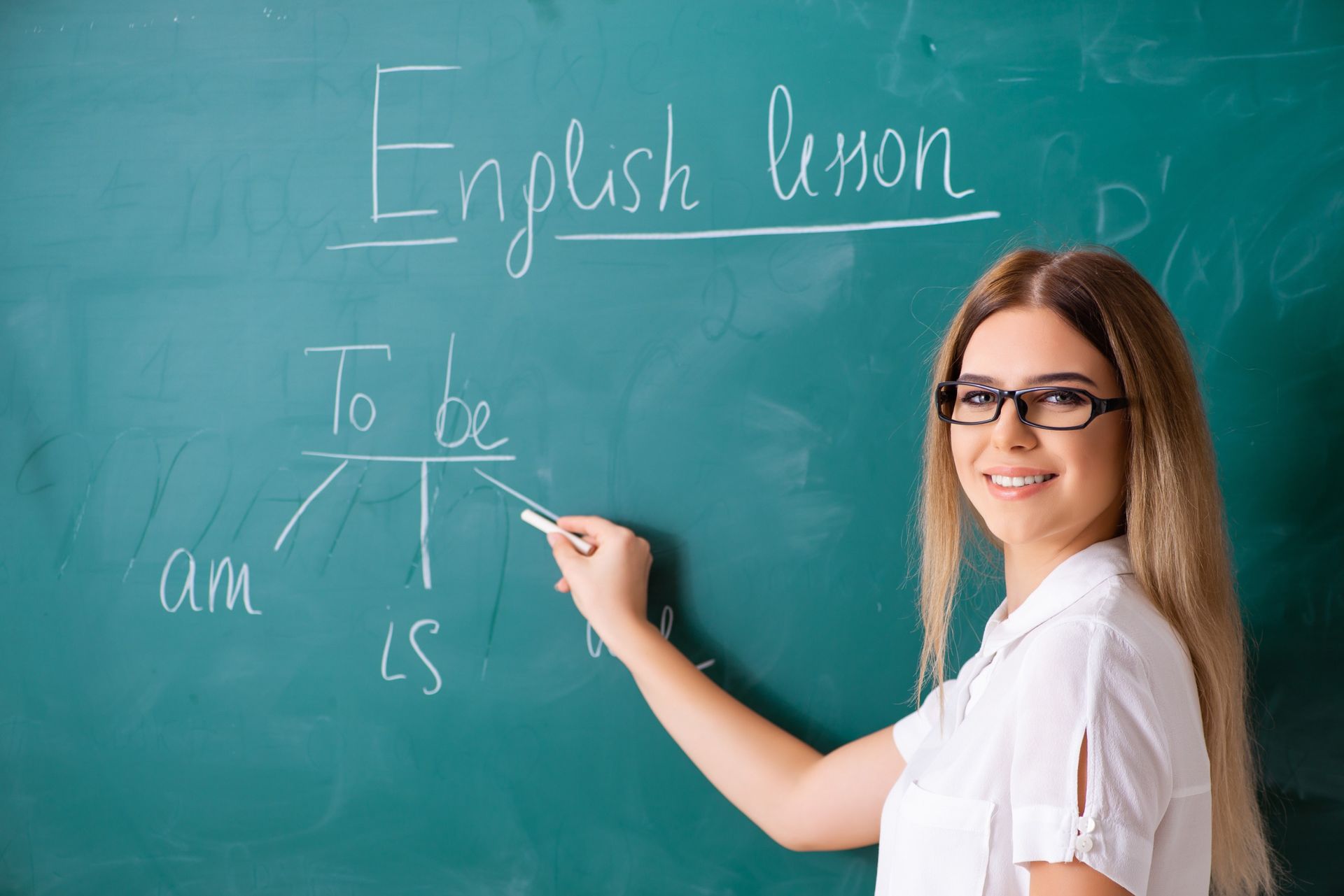 Mujer enseñando una lección de inglés en la pizarra, escribiendo