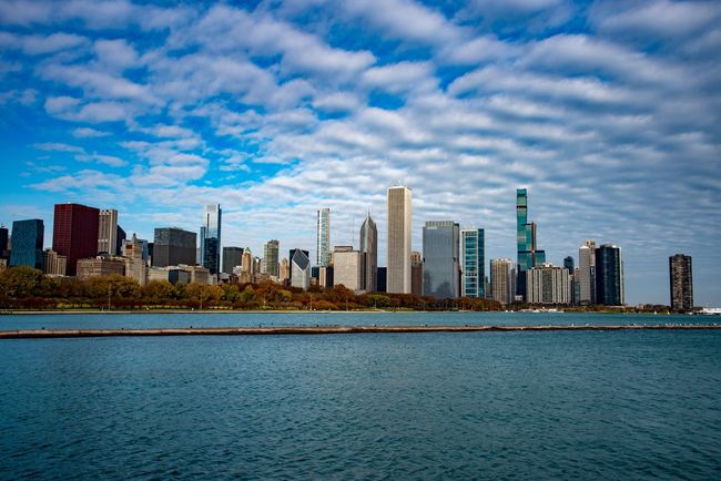 Horizonte de Chicago desde el lago Michigan bajo un cielo azul con nubes estampadas.