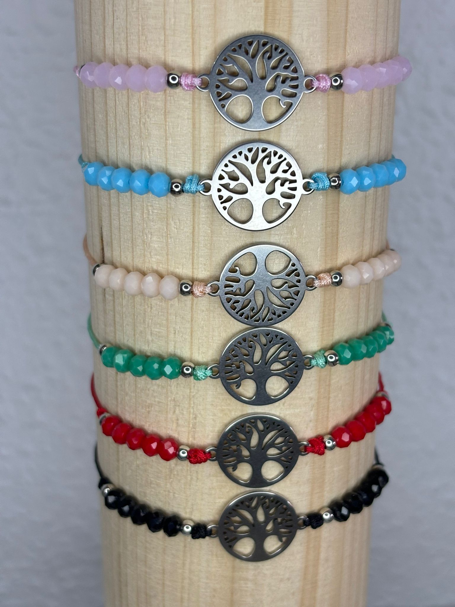 Un montón de pulseras se apilan una encima de otra en un poste de madera.