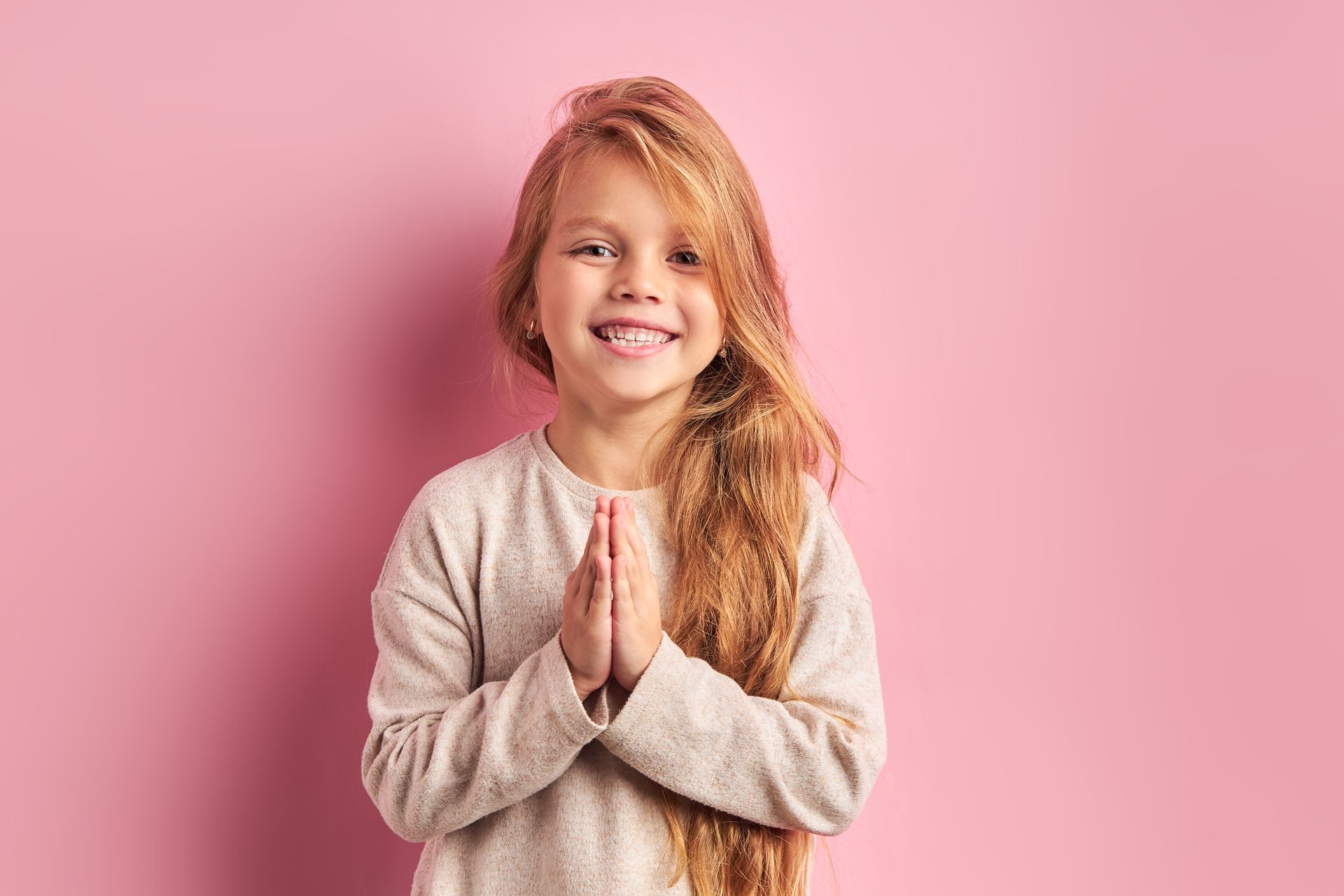 Jeune fille souriante avec longs cheveux sur fond rose