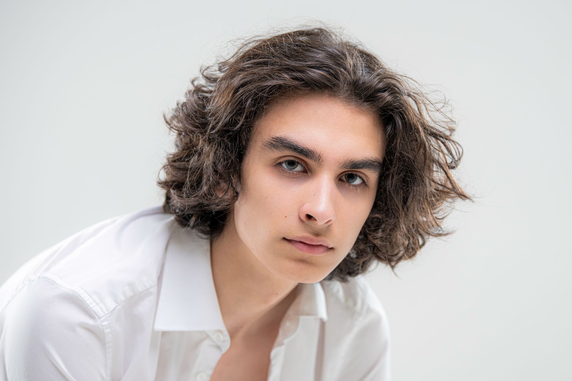 Homme avec cheveux mi-longs bouclés