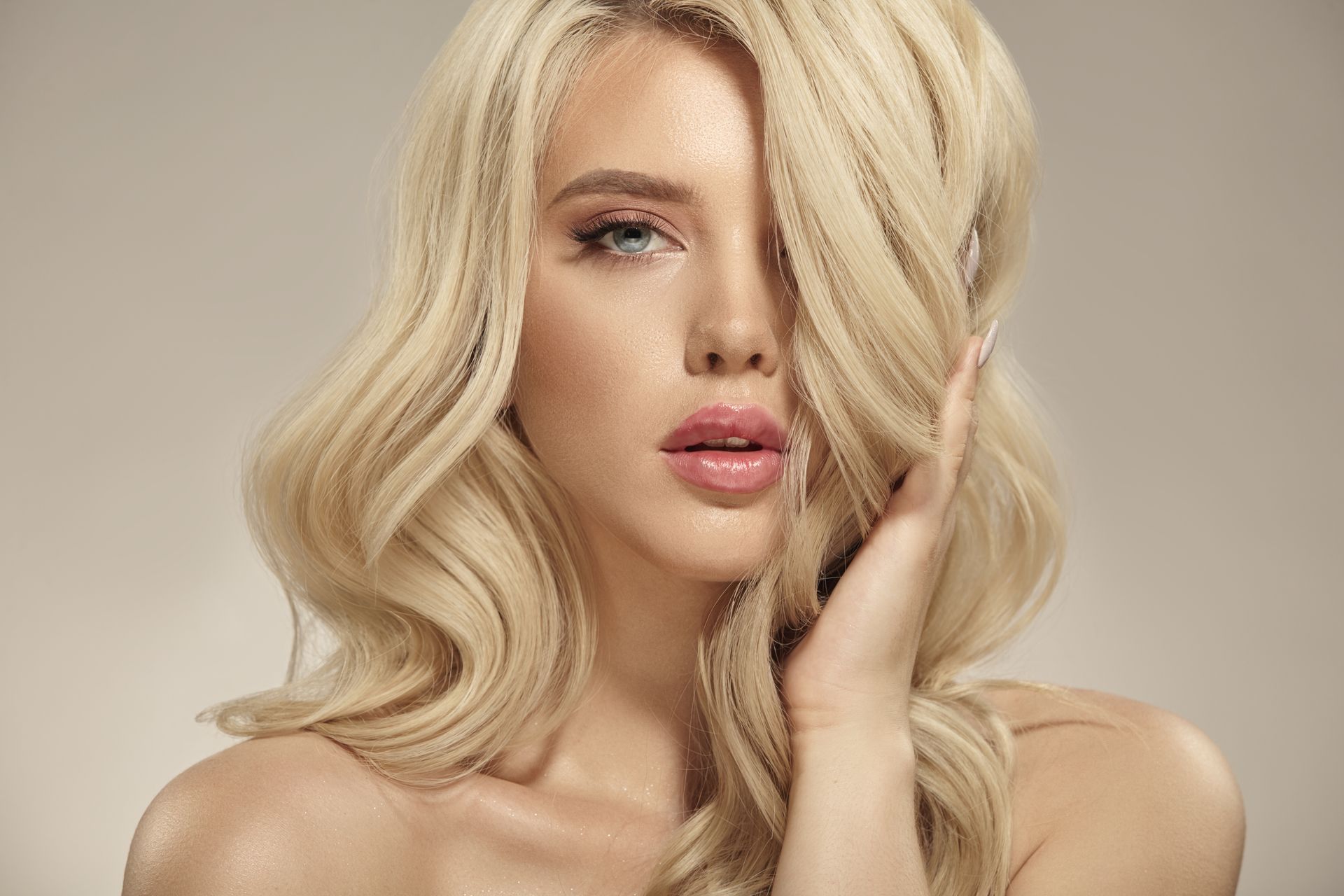 Femme qui passe une main dans ses cheveux blonds