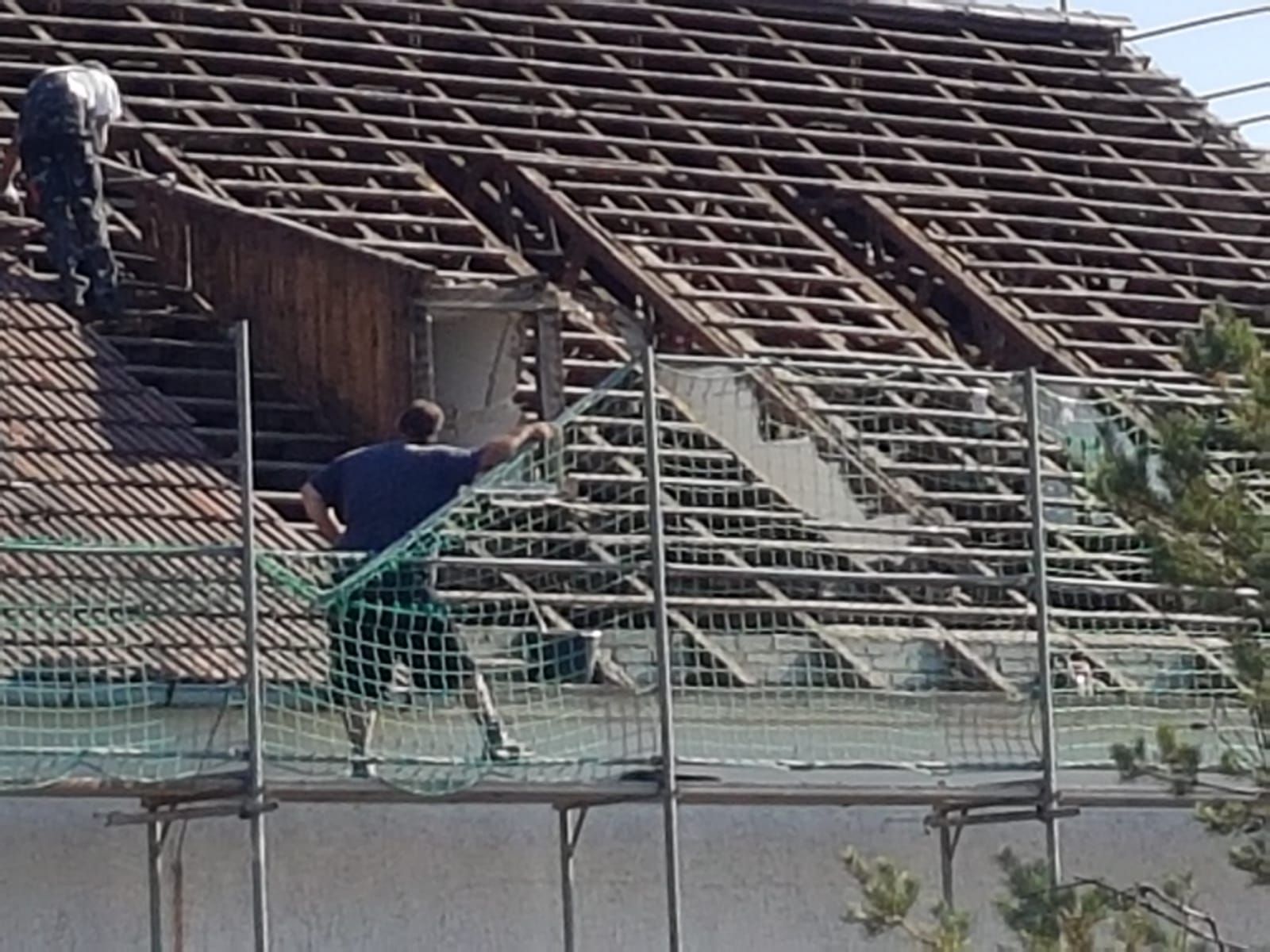 Zwei Männer arbeiten auf dem Dach eines Gebäudes