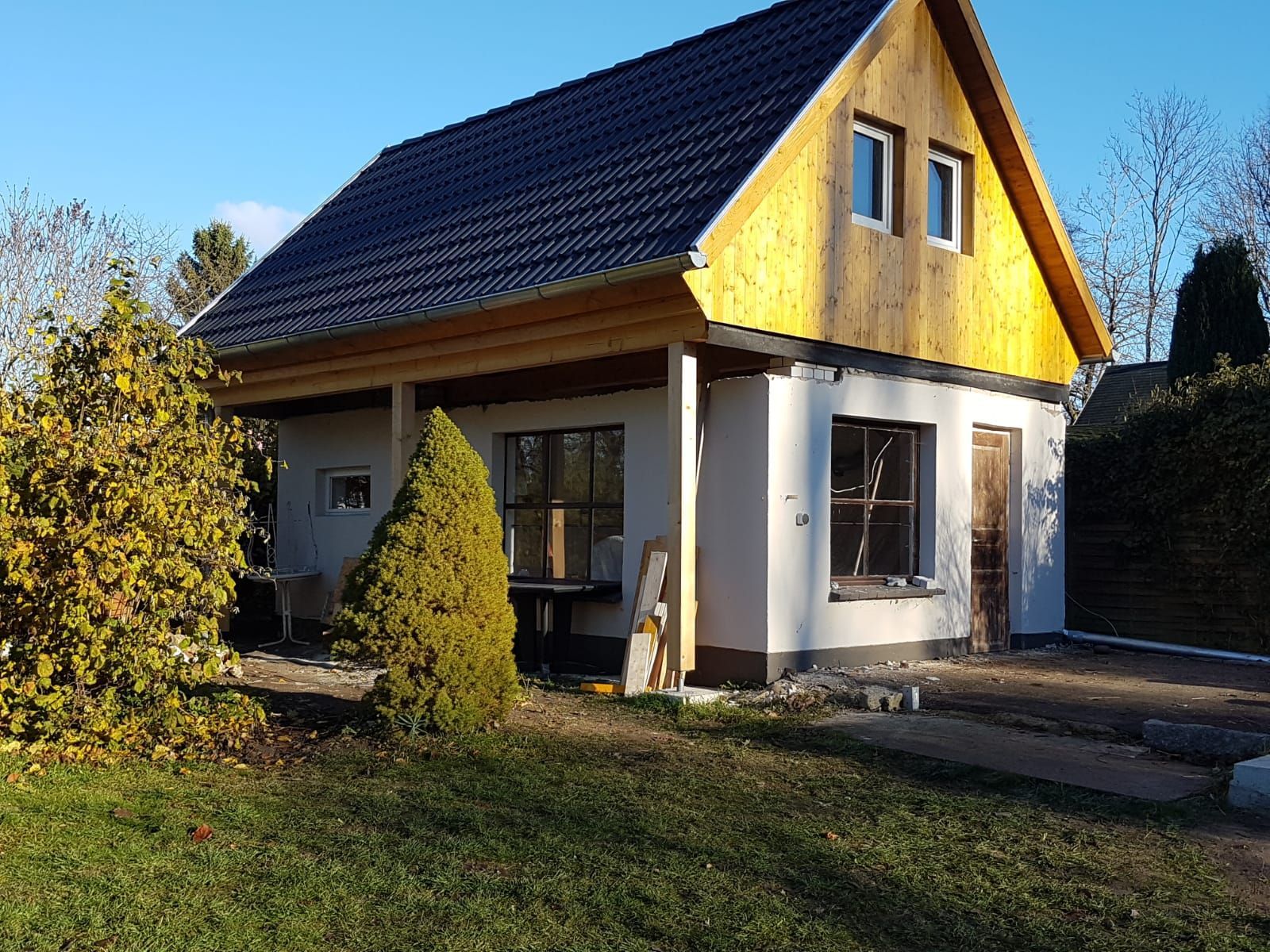 Ein kleines Haus mit einem gelben Dach und einem schwarzen Dach