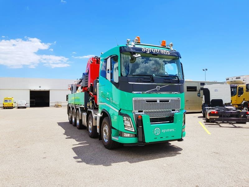 Un camión Volvo verde está estacionado en un estacionamiento.