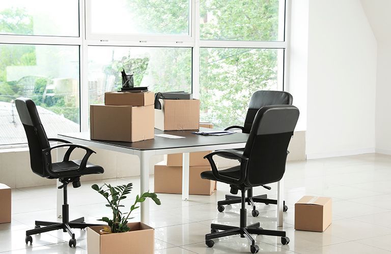 Un bureau avec des chaises et des cartons