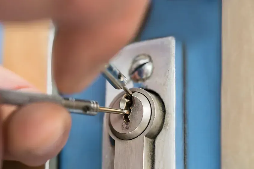 Una persona está usando un destornillador para abrir la cerradura de una puerta.