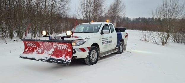 Blitz Blank – Schneeräumfahrzeug für den Winterdienst mit Schaufel und Warnbeleuchtung vor einer Winterlandschaft