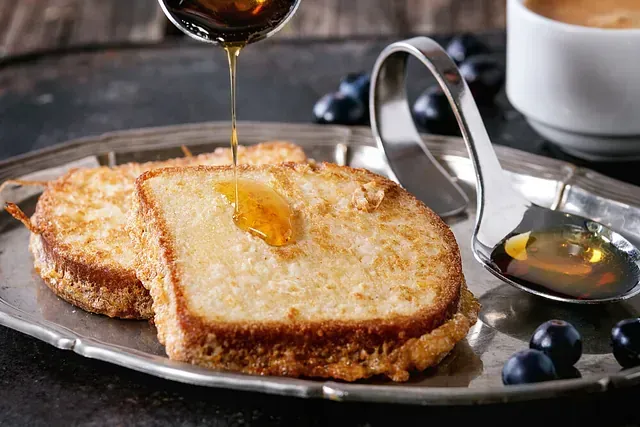 Se vierten tostadas francesas con almíbar en una bandeja de plata.