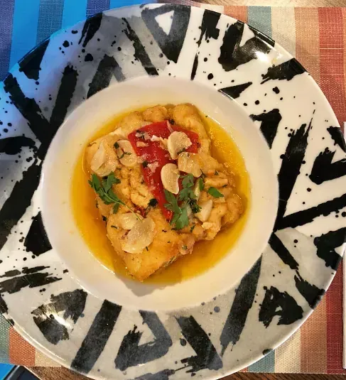 Un plato blanco y negro con un tazón de comida encima.