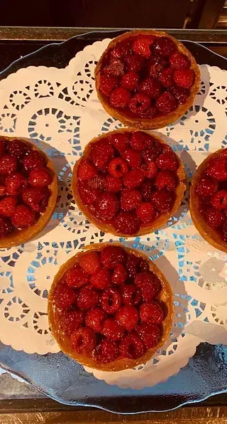 Un plato de tartas de frambuesa sobre una servilleta sobre una mesa.
