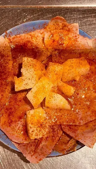 Un primer plano de una pizza en un plato sobre una mesa.