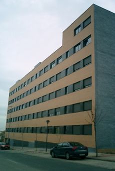 Un coche está aparcado delante de un gran edificio.