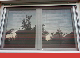 Un primer plano de una ventana con una pantalla encima.