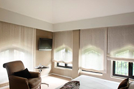 Un dormitorio con una cama, una silla y una televisión.