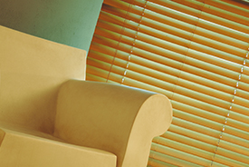 Una silla está sentada delante de una ventana con persianas.