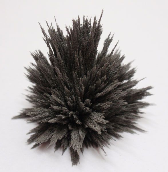 Eisenfeilspäne sammelten sich um einen Magneten und bildeten eine stachelige, dunkelgraue Form.