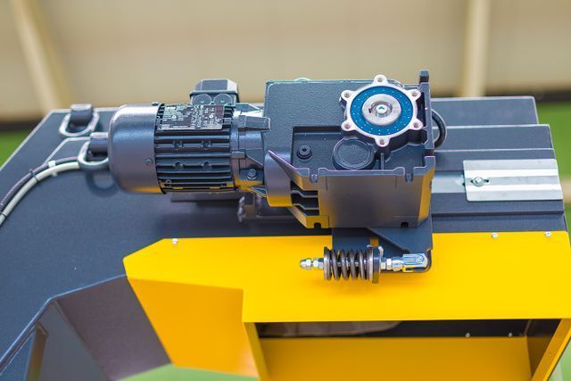 Elektromotormontage an gelben und grauen Maschinen.