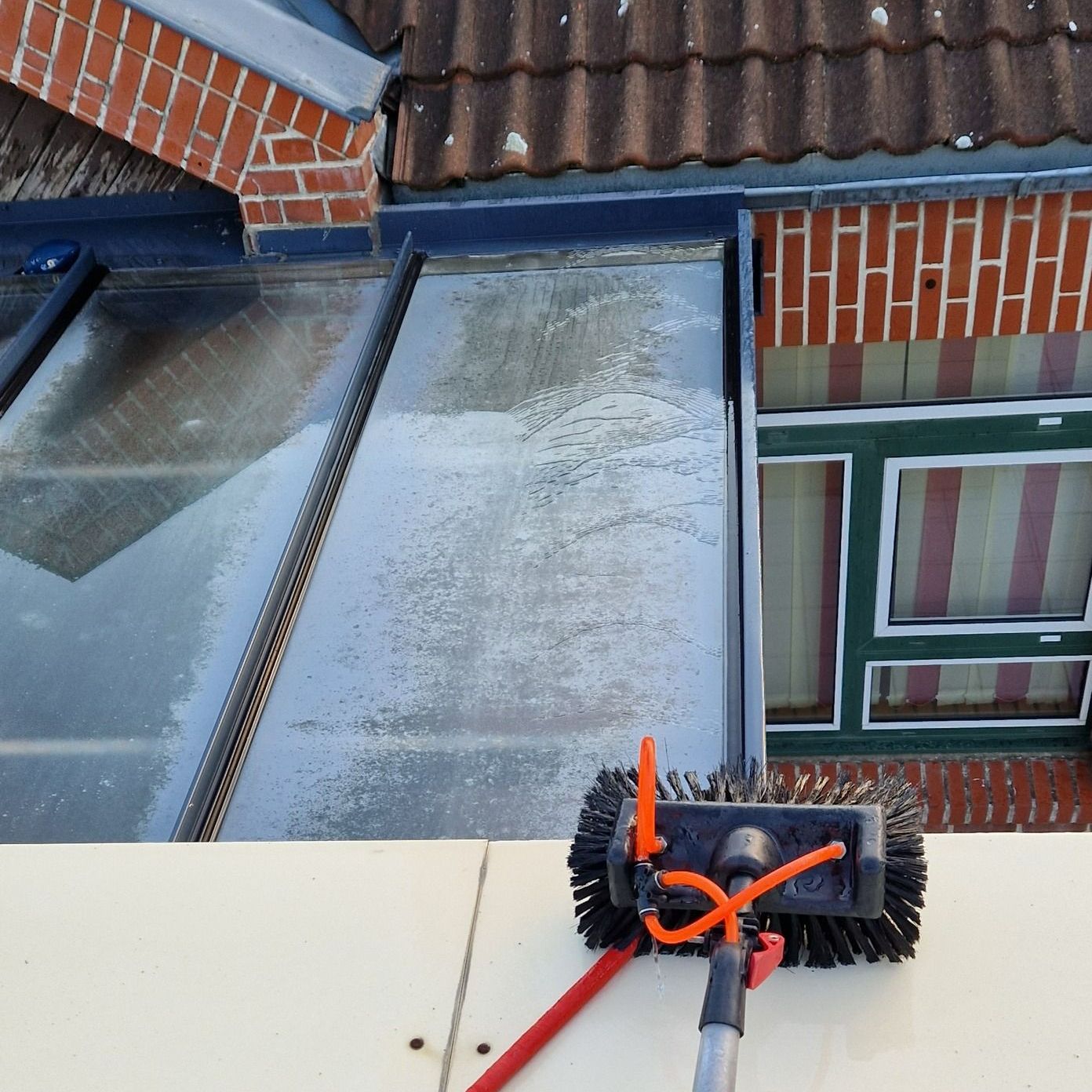 Vitres en hauteur d'une véranda en cours de nettoyage