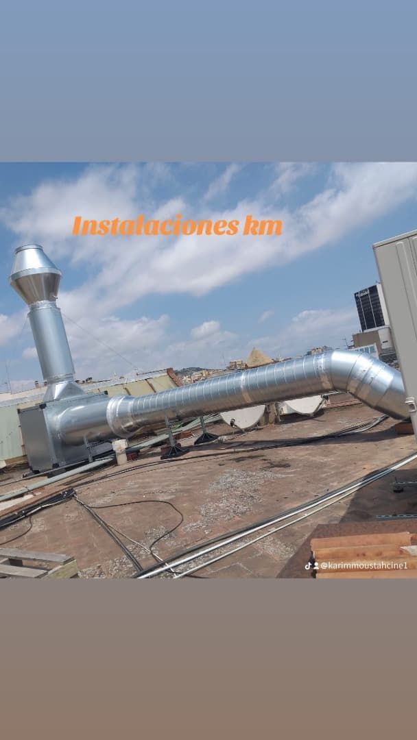 Sistema de ventilación de metal en una azotea contra un cielo azul.