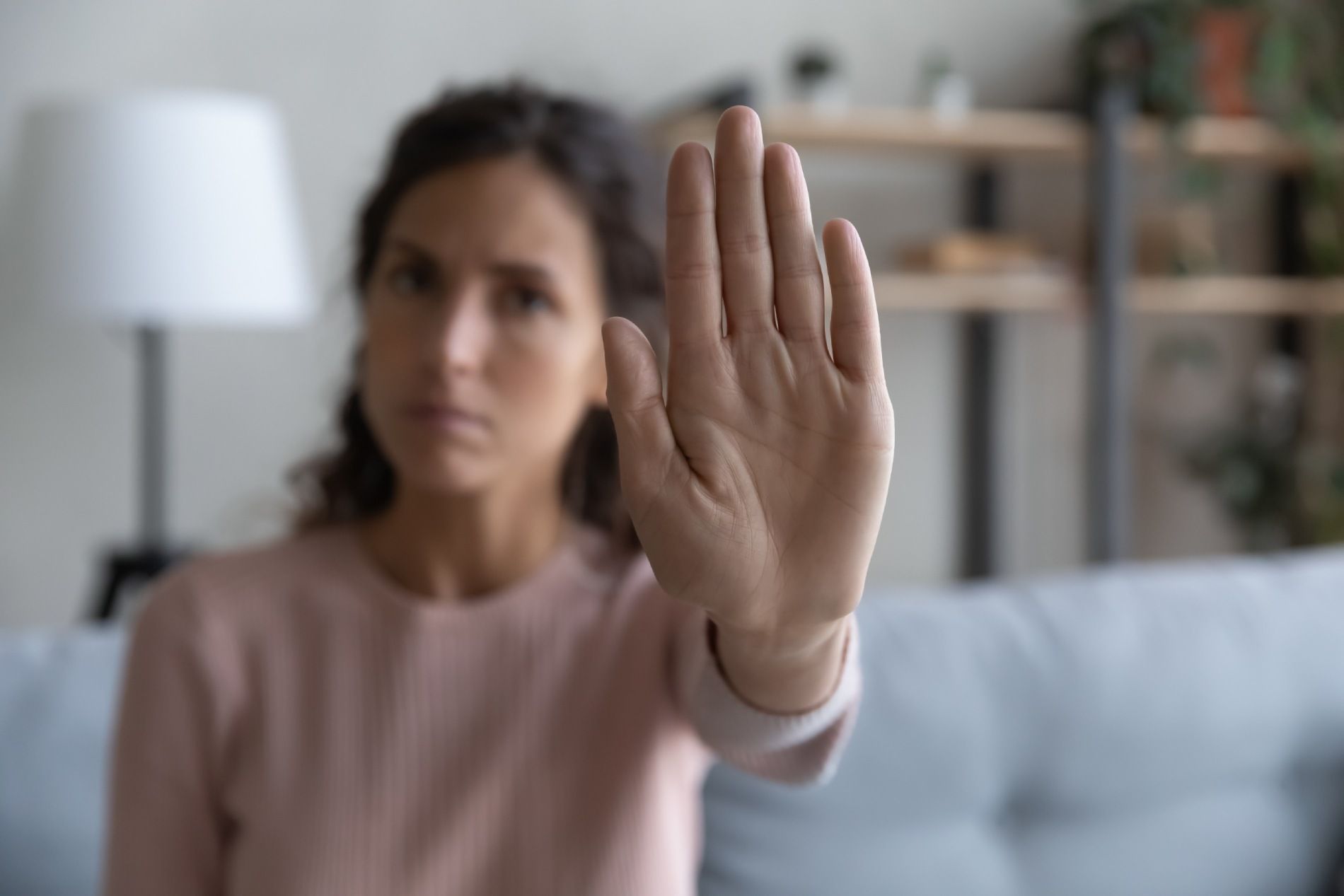 Mujer levantando la mano para detener la cámara en una sala de estar.